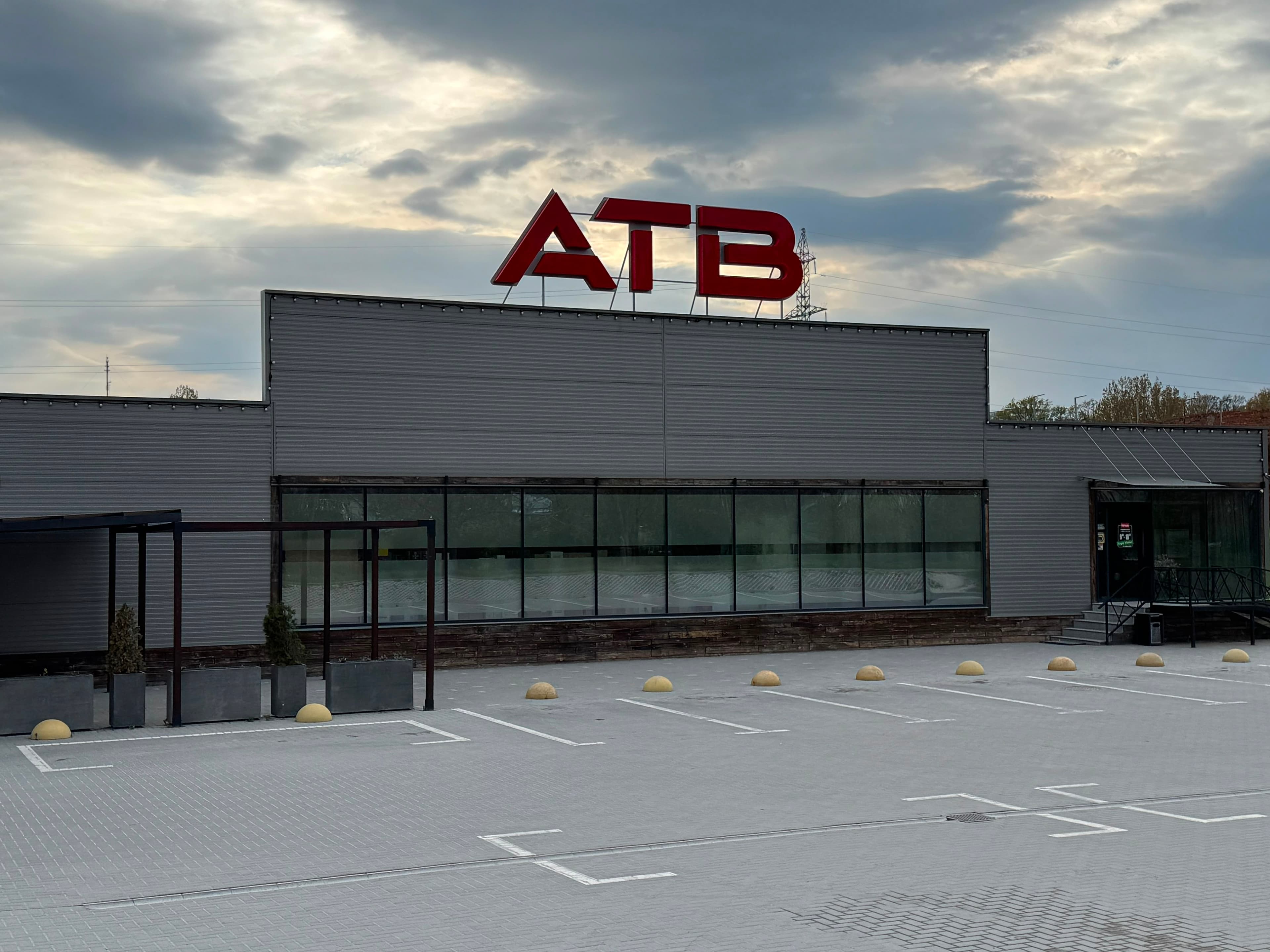 Магазин ATB-Market в Бельцах вечером, вид на вывеску и главный фасад