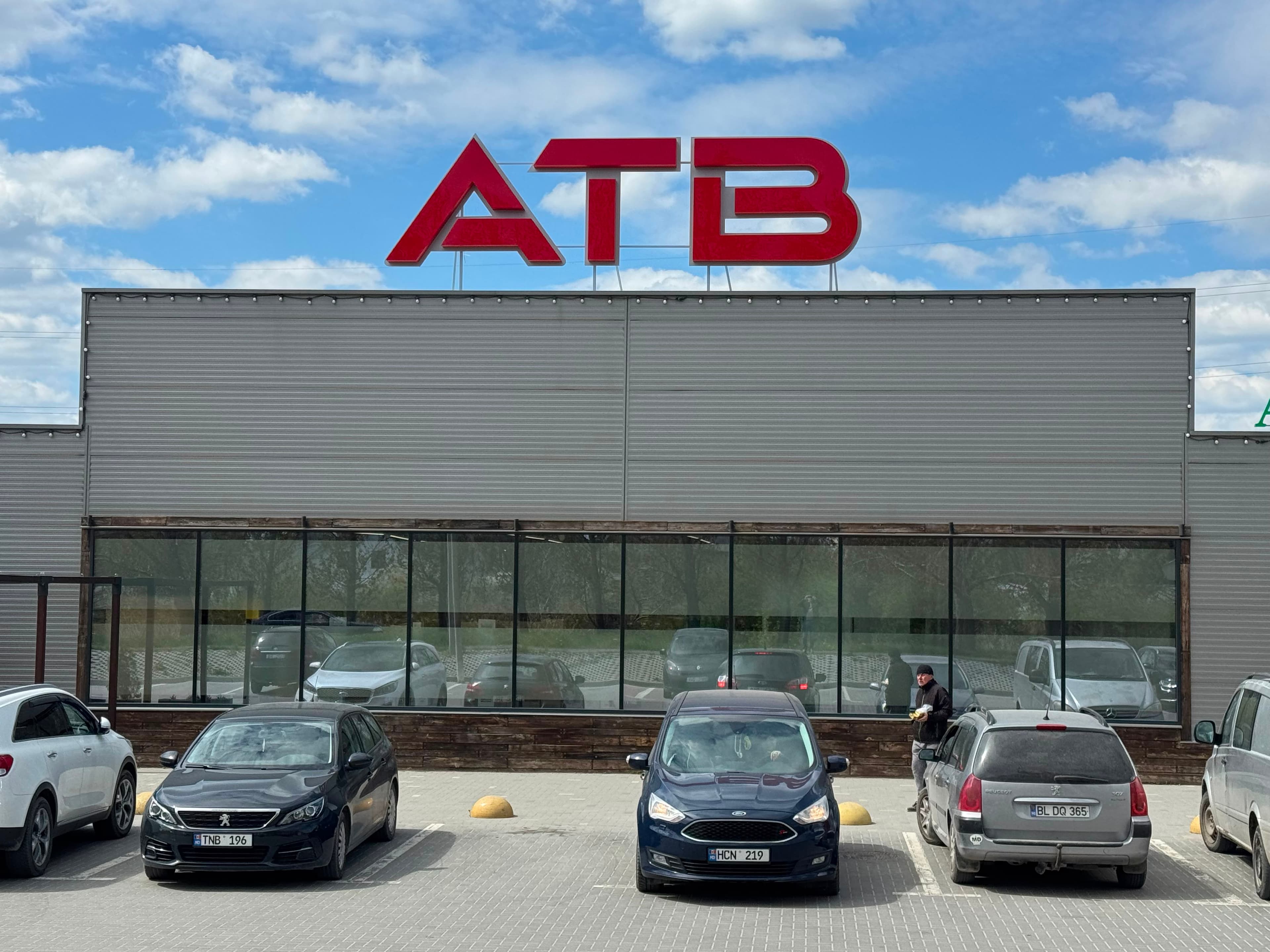 Крупный вид красной вывески ATB на фасаде магазина